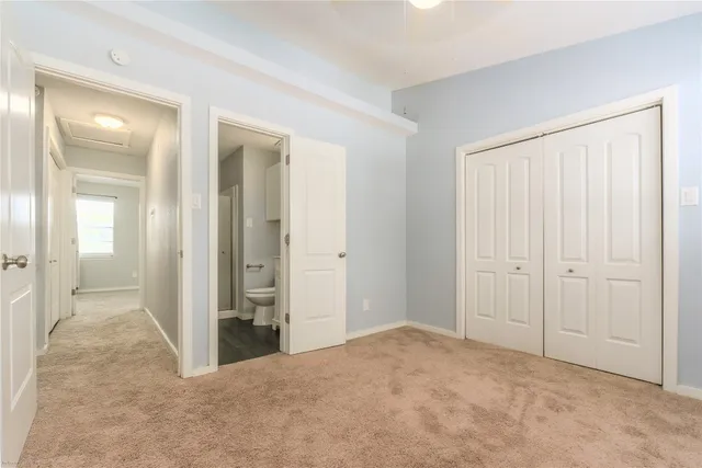 an empty room with closet and mirror