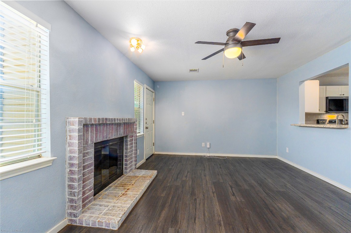 1845 River Crossing Circle, Unit C Austin, TX 78741 - Photo 2 of 28 a view of empty room with wooden floor and fireplace