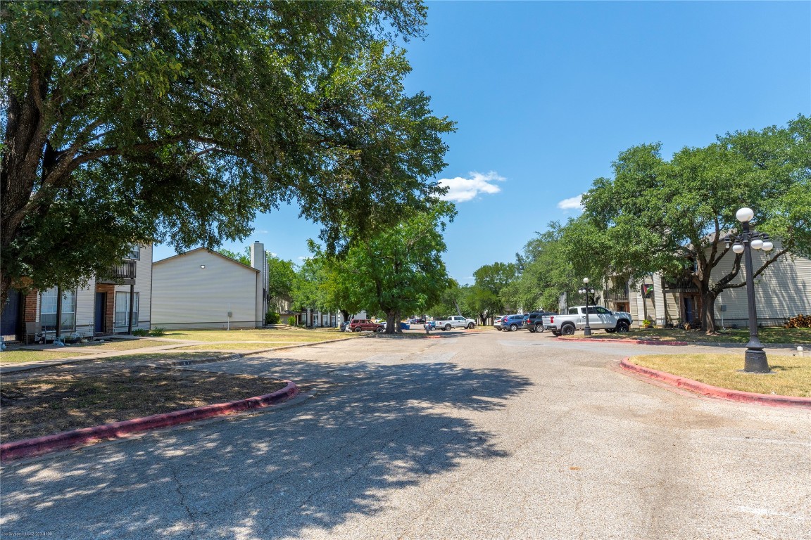 1845 River Crossing Circle, Unit C Austin, TX 78741 - Photo 25 of 28 a front view of a house with a yard and trees