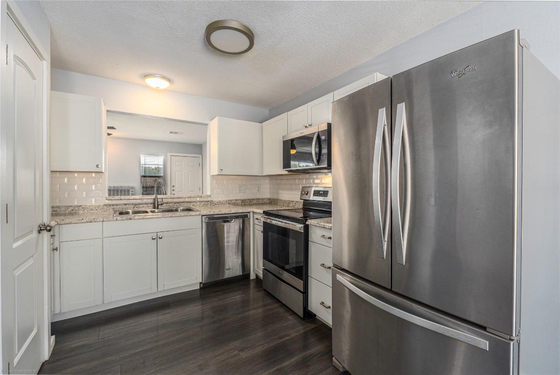 1845 River Crossing Circle, Unit C Austin, TX 78741 - Photo 3 of 28 a kitchen with a refrigerator sink and cabinets