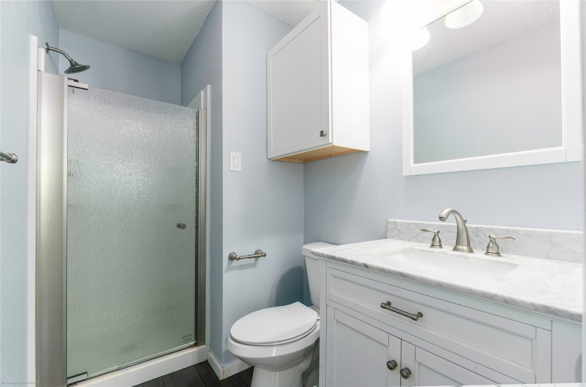 1845 River Crossing Circle, Unit C Austin, TX 78741 - Photo 6 of 28 a bathroom with a toilet a sink a vanity and mirror