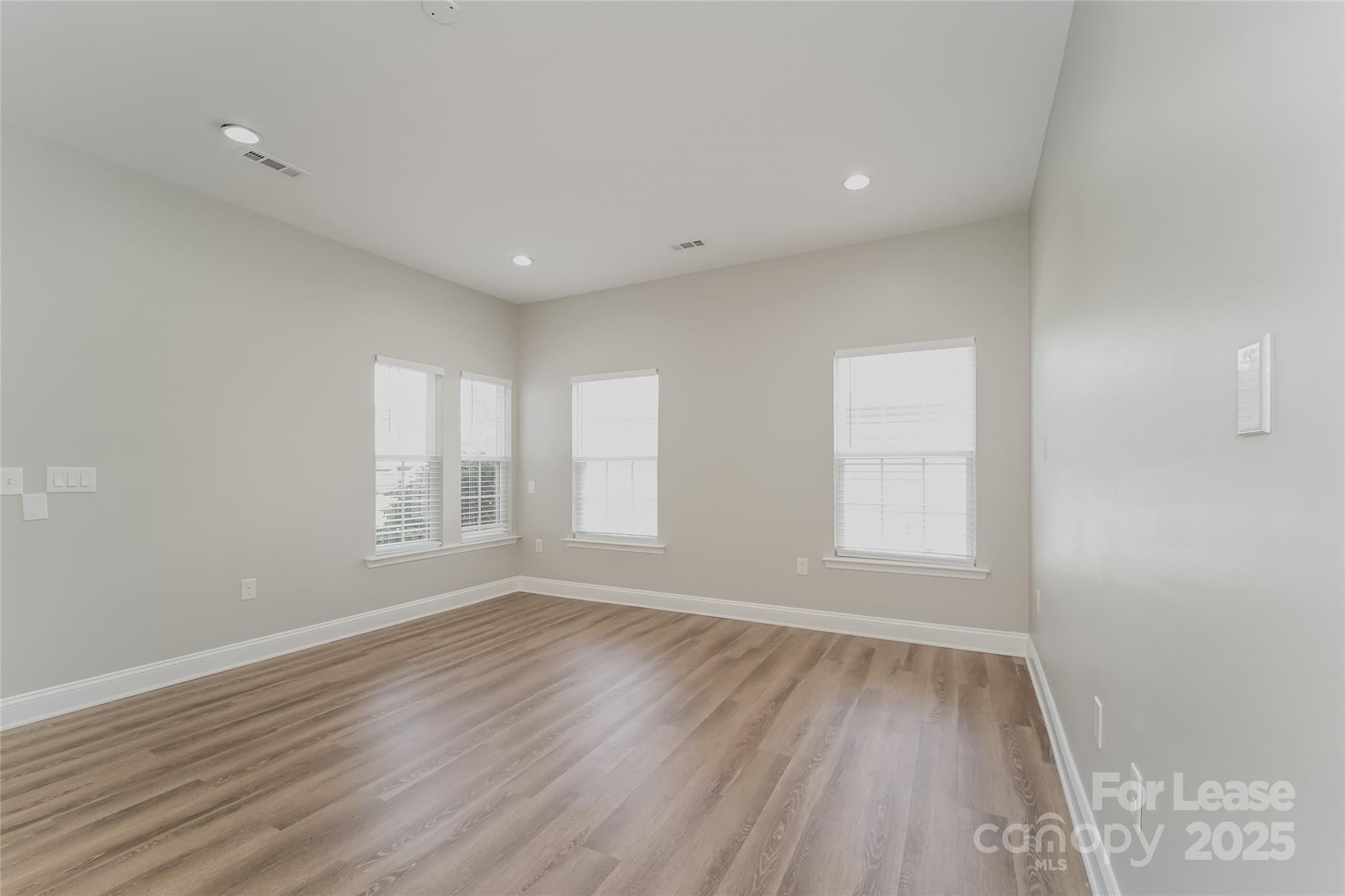4416 Marys Point Road Monroe, NC 28110 - Photo 6 of 12 an empty room with wooden floor and windows