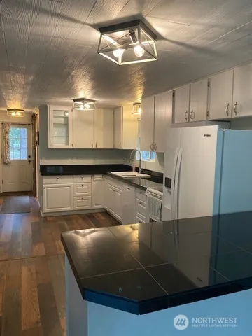 a kitchen with stainless steel appliances granite countertop a sink a refrigerator and a stove