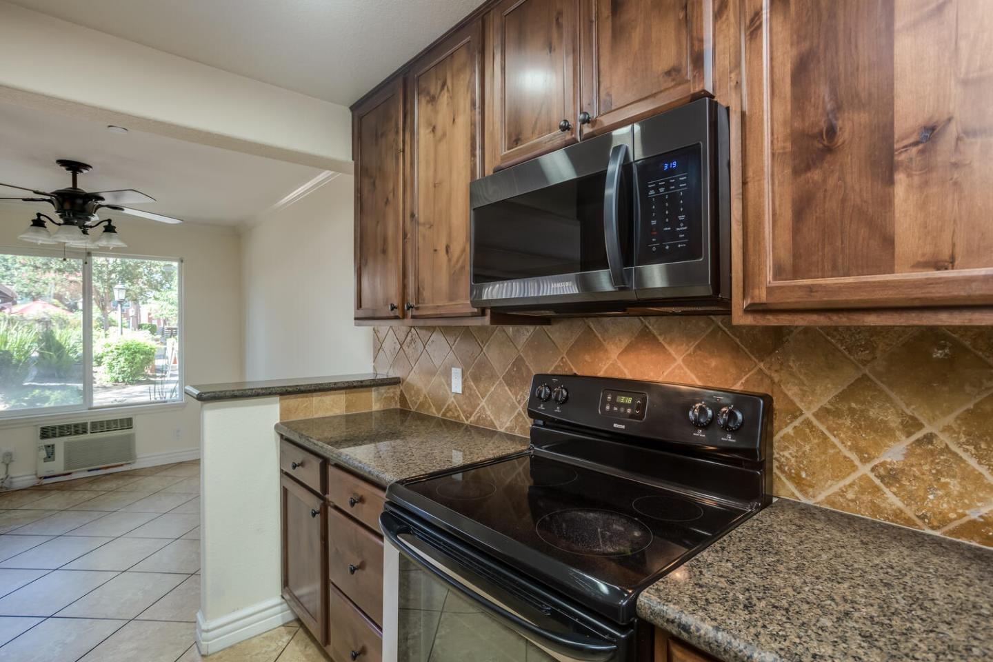 2580 Homestead Road, Unit 5101 Santa Clara, CA 95051 - Photo 11 of 33 a kitchen with granite countertop a stove top oven cabinetry a sink and a window