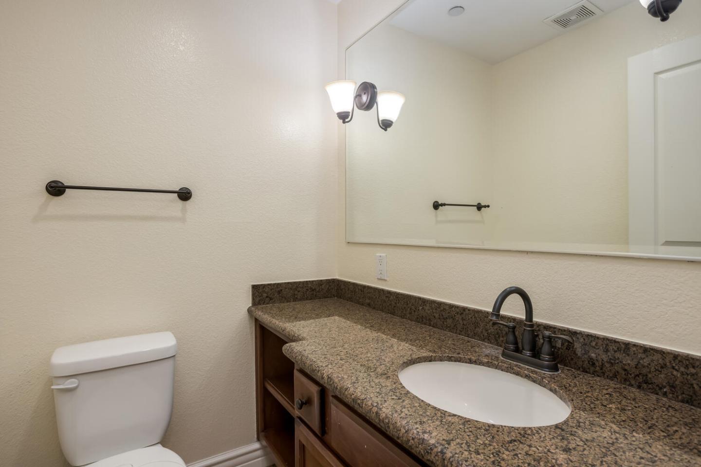 2580 Homestead Road, Unit 5101 Santa Clara, CA 95051 - Photo 21 of 33 a bathroom with a granite countertop sink a toilet and mirror