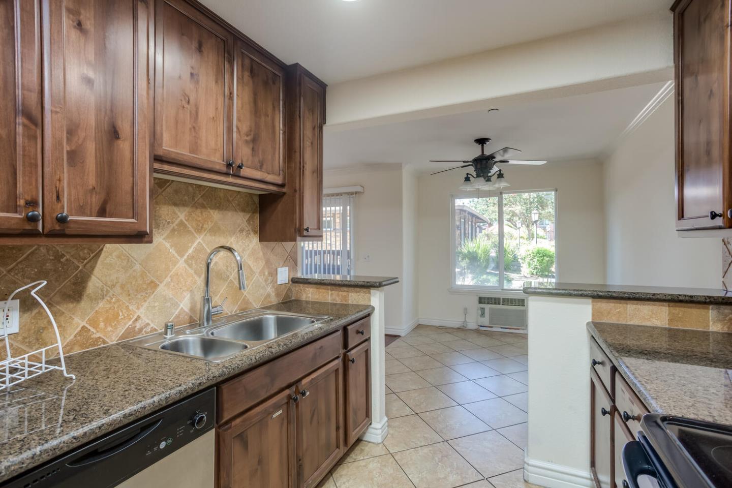 2580 Homestead Road, Unit 5101 Santa Clara, CA 95051 - Photo 9 of 33 a kitchen with kitchen island granite countertop a sink stainless steel appliances cabinets and a counter top space