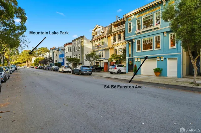 a kitchen with kitchen island a stove a sink a refrigerator and cabinets