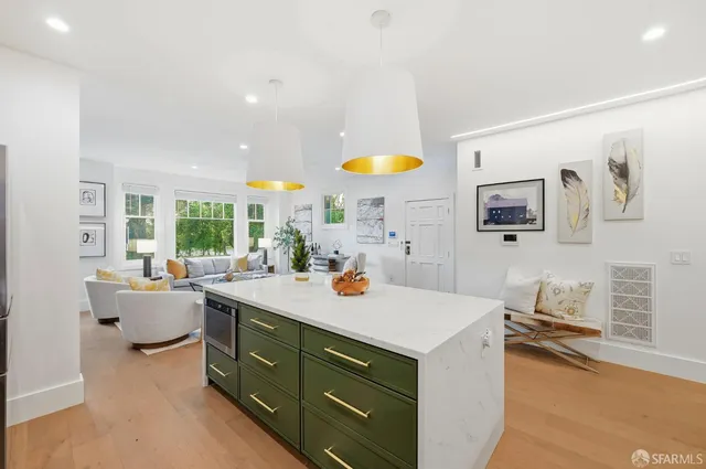 a kitchen with stainless steel appliances a refrigerator a stove and white cabinets