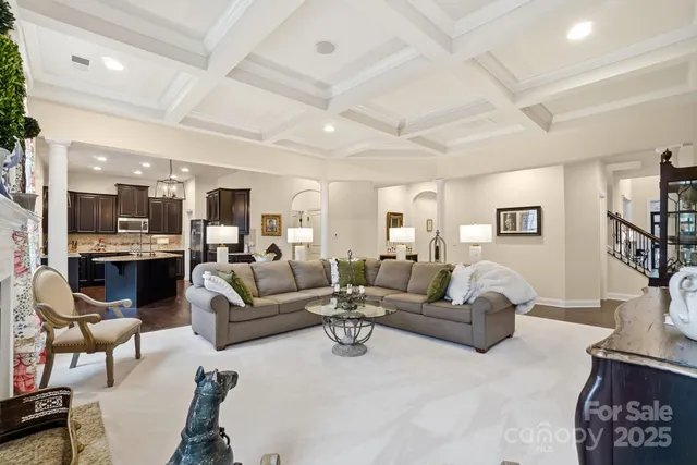 a kitchen with stainless steel appliances kitchen island granite countertop a refrigerator a stove a sink a dining table and chairs with wooden floor