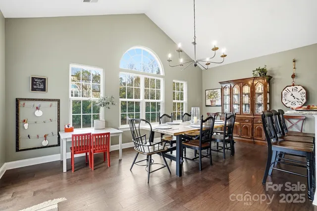a spacious bedroom with a bed a dresser and a chandelier