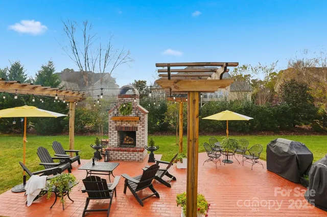 a view of a patio with table and chairs potted plants and large tree