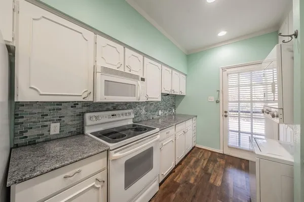 a kitchen with granite countertop a sink and a stove next to a window