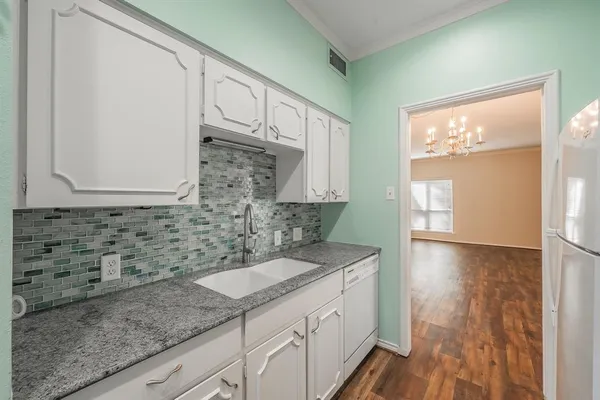 a bathroom with a granite countertop sink a mirror and a shower