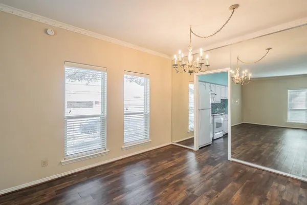 a view of a livingroom with a chandelier fan and windows