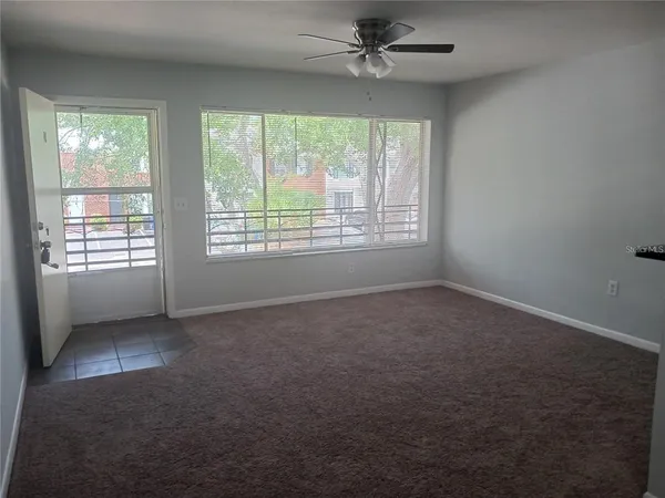 a view of a livingroom with a ceiling fan and window