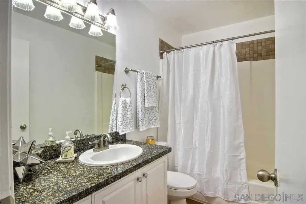 17119 West Bernardo Drive, Unit 108 San Diego, CA 92127 - Photo 11 of 18 a bathroom with a granite countertop double vanity sink and a mirror