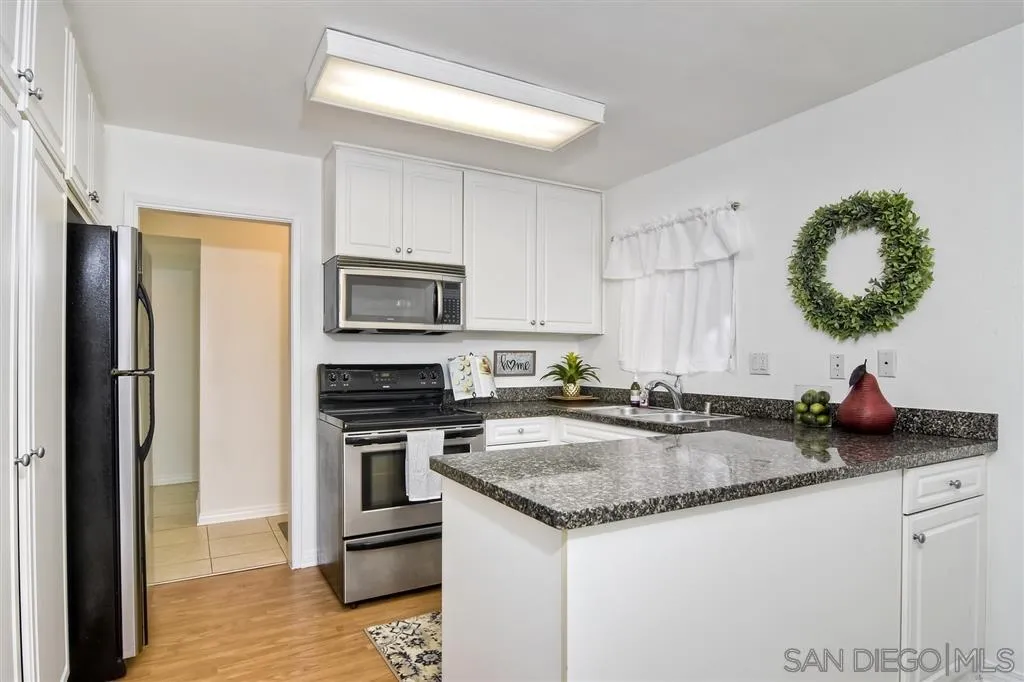 17119 West Bernardo Drive, Unit 108 San Diego, CA 92127 - Photo 5 of 18 a kitchen with microwave cabinets and stainless steel appliances