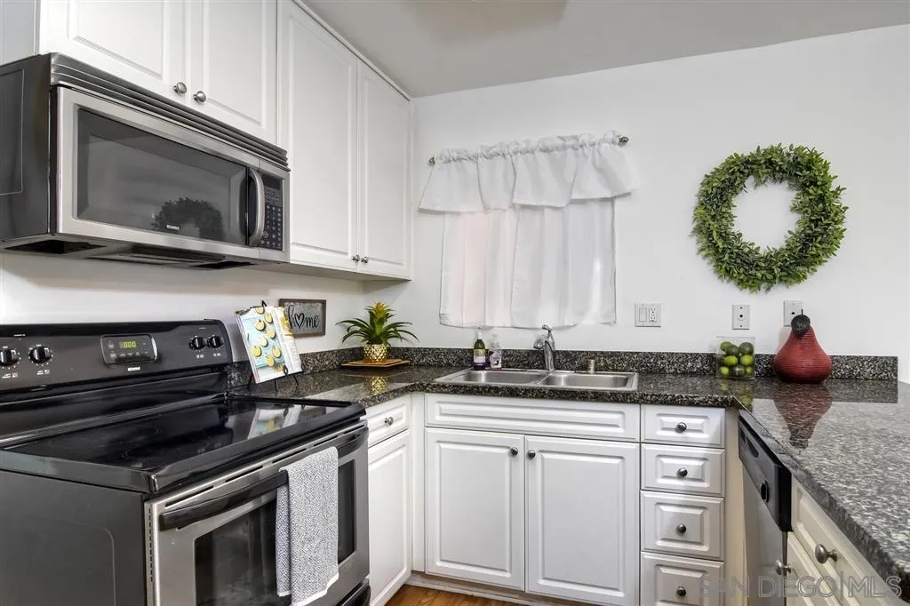 17119 West Bernardo Drive, Unit 108 San Diego, CA 92127 - Photo 6 of 18 a kitchen with stainless steel appliances a stove a microwave a sink and cabinets