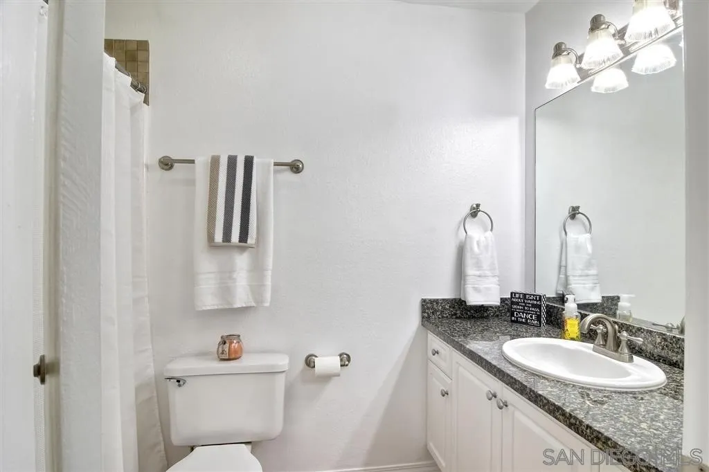 17119 West Bernardo Drive, Unit 108 San Diego, CA 92127 - Photo 10 of 18 a bathroom with a granite countertop sink a toilet and a mirror