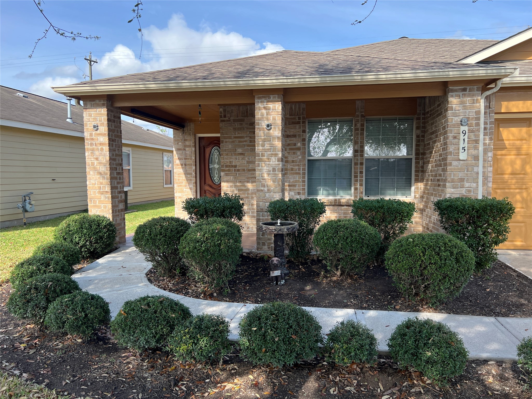 a front view of a house with garden and plants