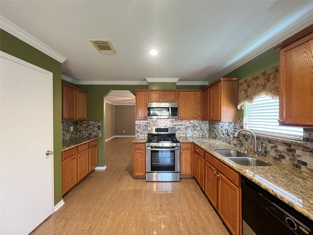 915 Wild Cotton Road Rosenberg, TX 77471 - Photo 11 of 38 a kitchen with stainless steel appliances granite countertop a stove and a sink