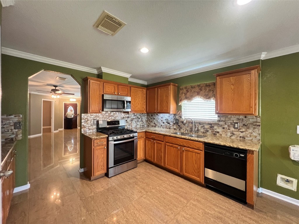 915 Wild Cotton Road Rosenberg, TX 77471 - Photo 12 of 38 a kitchen with stainless steel appliances granite countertop a stove and a sink