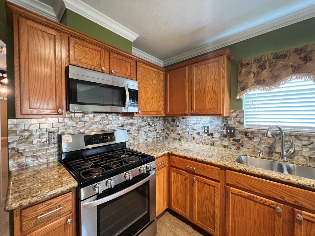 915 Wild Cotton Road Rosenberg, TX 77471 - Photo 9 of 38 a kitchen with sink a microwave a stove and cabinets