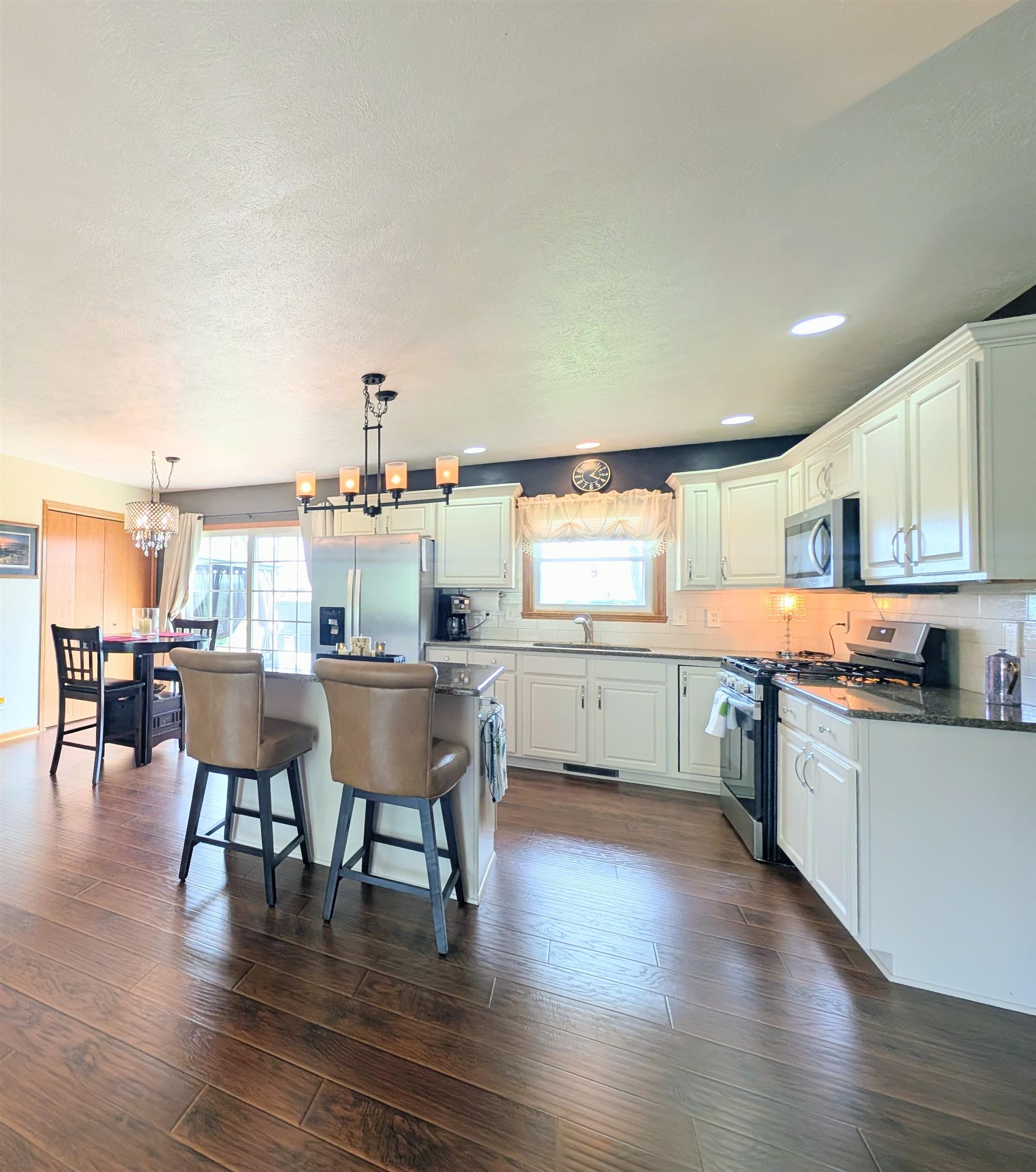 727 Westmore Road Davis, IL 61019 - Photo 6 of 32 a kitchen with stainless steel appliances kitchen island wooden floors and white cabinets