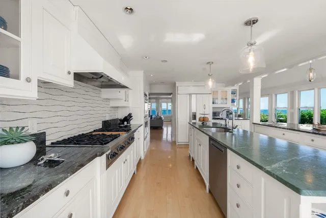 a kitchen with stainless steel appliances kitchen island granite countertop a table and chairs in it