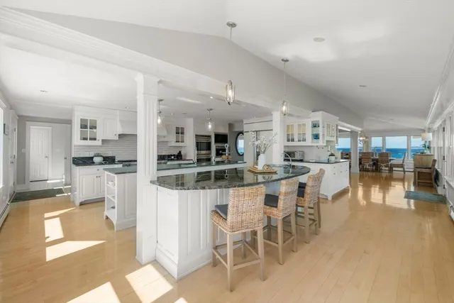 a view of a dining room and livingroom with furniture wooden floor a chandelier