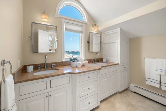 a bathroom with a tub a sink double vanity and a mirror