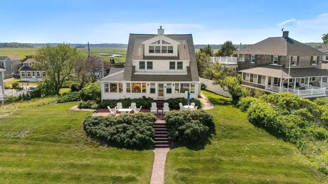 a view of a house with a big yard plants and large trees