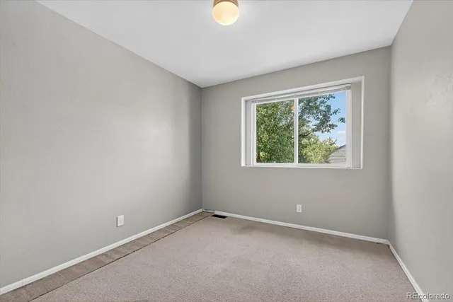 an empty room with a window and a mirror