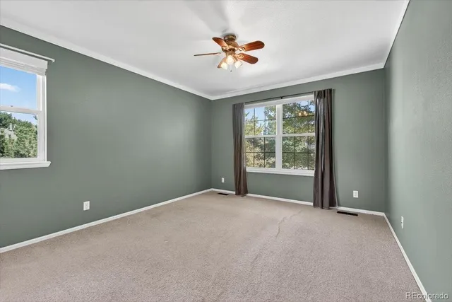 an empty room with a ceiling fan and window