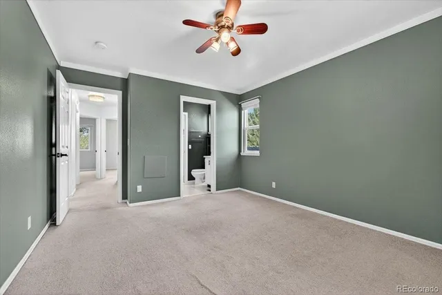 a view of a big room with windows and chandelier fan