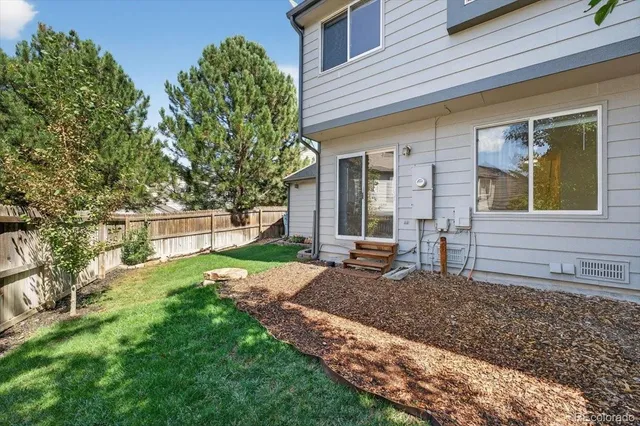 a view of a house with backyard and a tree