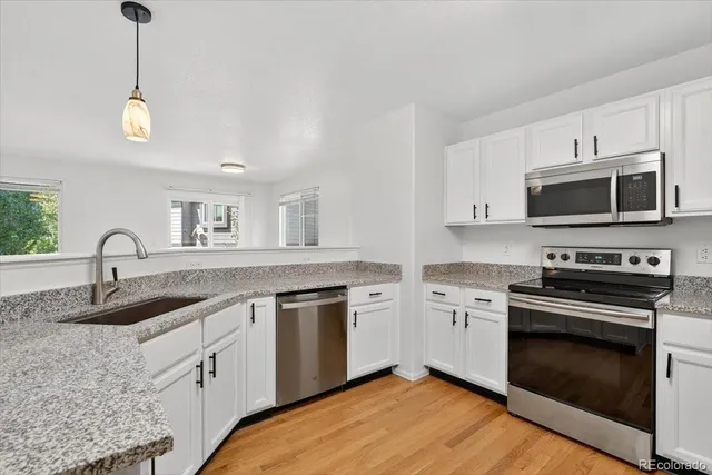 a kitchen with stainless steel appliances granite countertop a stove a sink and a microwave