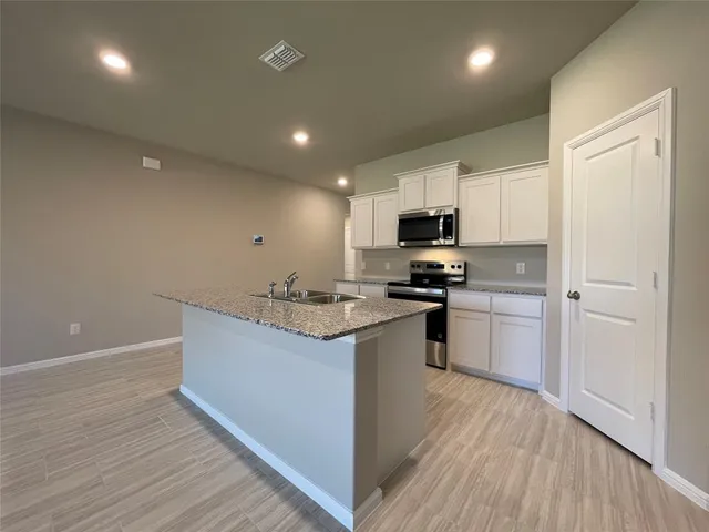 a kitchen with granite countertop a sink stove and refrigerator