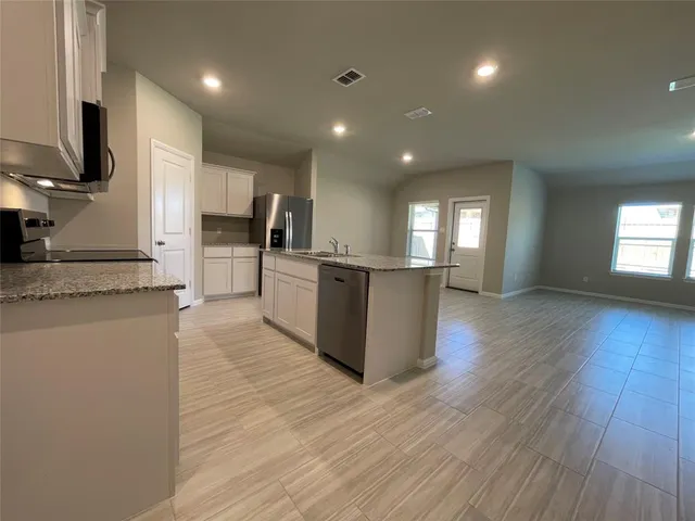 a view of kitchen with wooden floor and electronic appliances