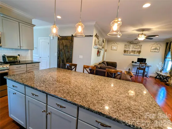 a large kitchen with kitchen island a large counter space and stainless steel appliances