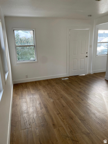 230 North 2nd Street Tooele, UT 84074 - Photo 5 of 18 Spacious room featuring wood-finish flooring, white walls, and a paneled entry door