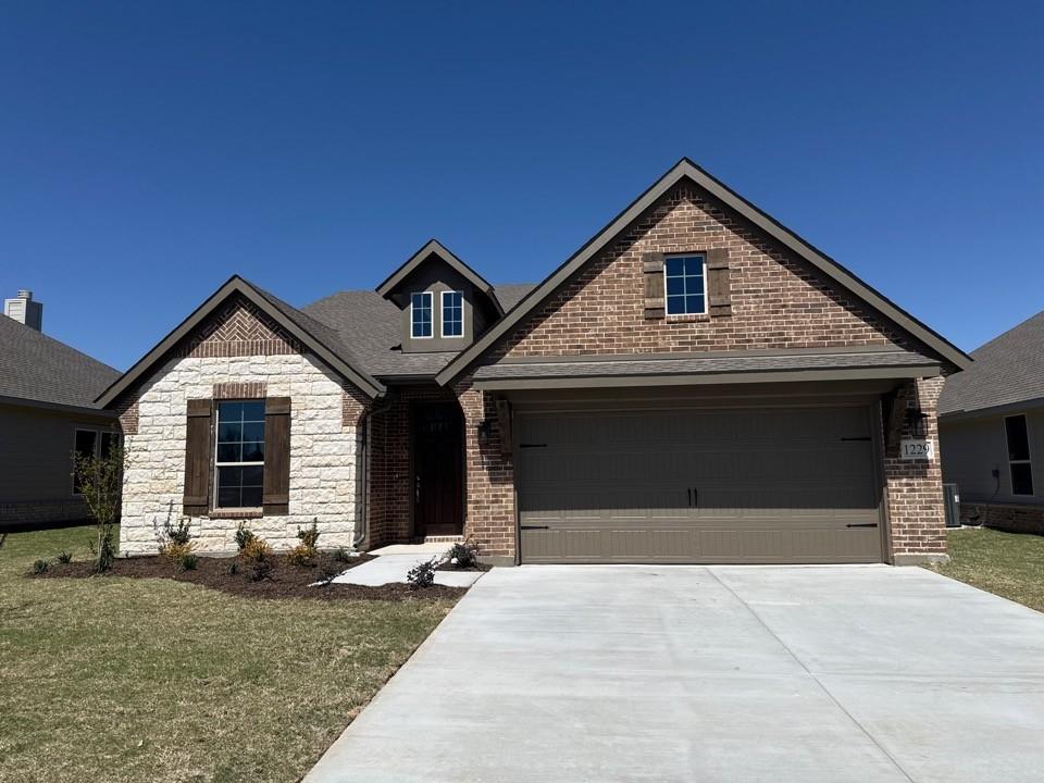 a front view of a house with yard and garage