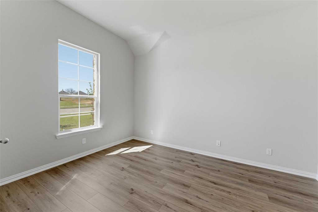 1229 Sabine River Lane Springtown, TX 76082 - Photo 6 of 26 a view of an empty room with wooden floor and a window