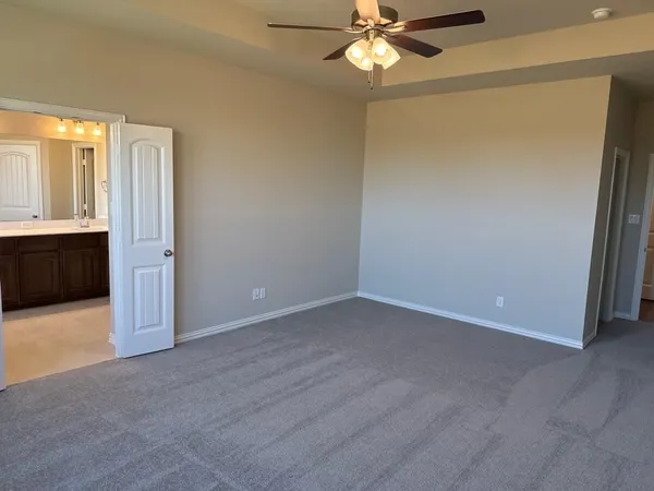 an empty room with closet and a chandelier fan