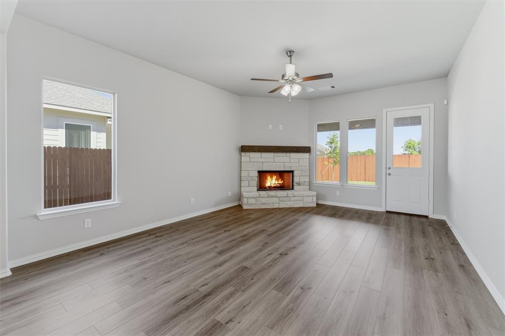 1229 Sabine River Lane Springtown, TX 76082 - Photo 7 of 26 an empty room with wooden floor fireplace and windows