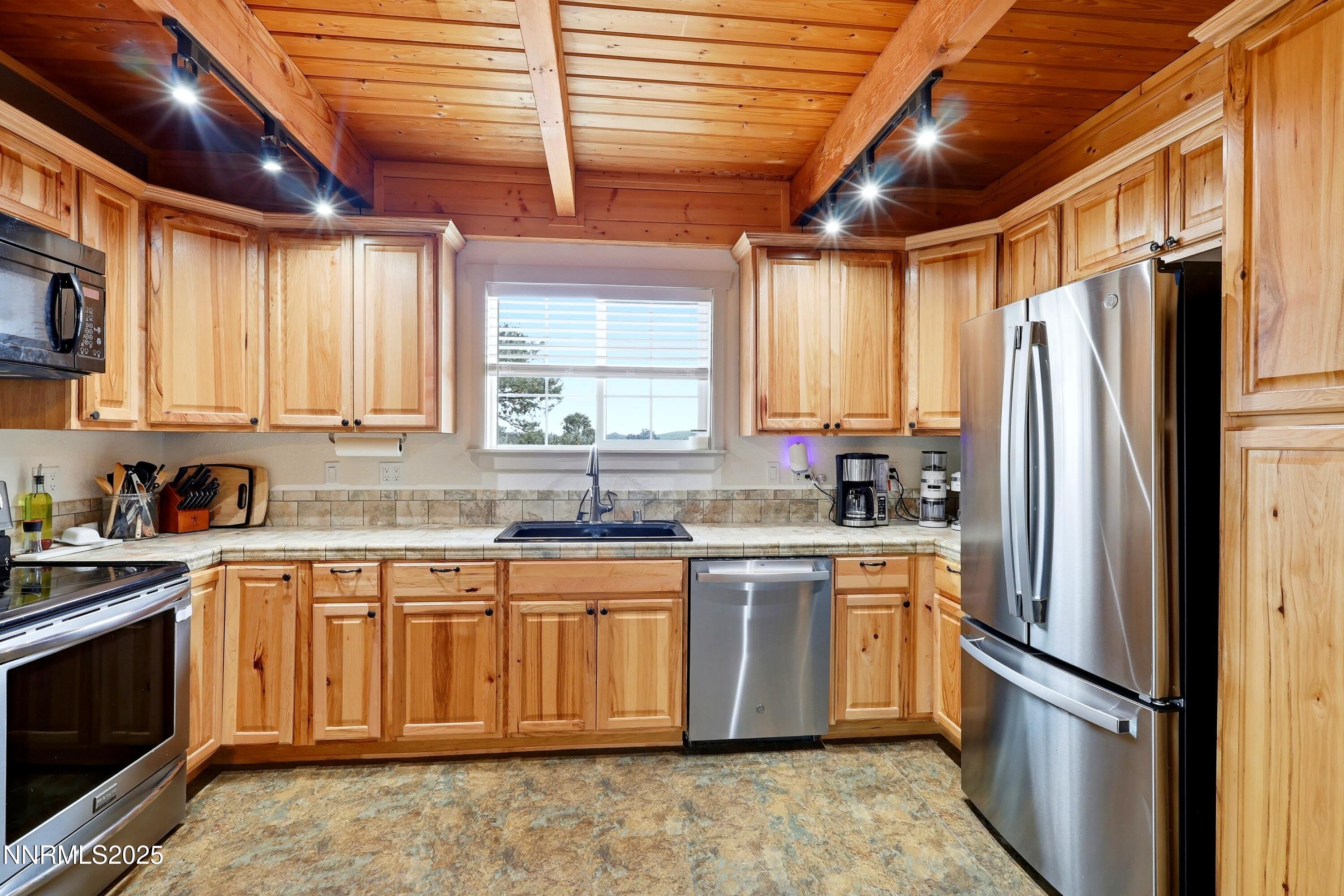 1590 Combination Road Reno, NV 89521 - Photo 21 of 41 a kitchen with stainless steel appliances granite countertop a stove a sink dishwasher a refrigerator and cabinets