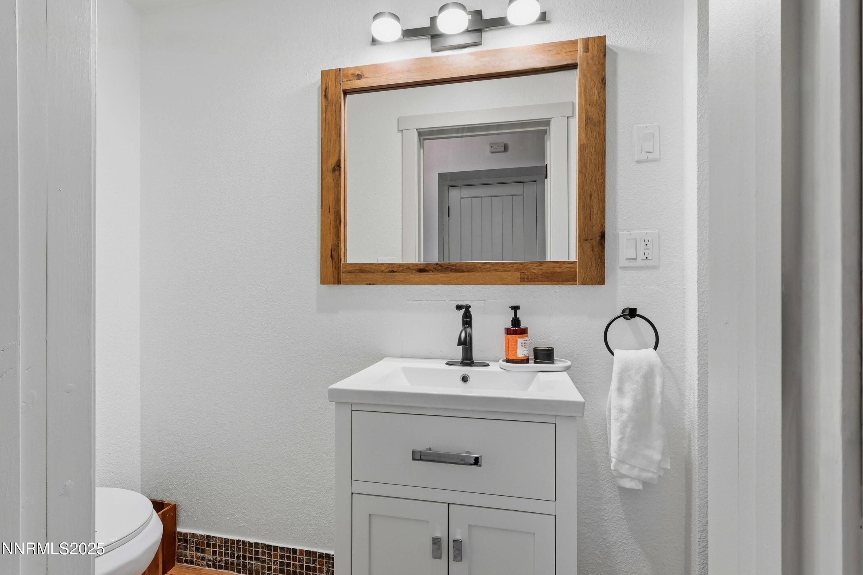 1590 Combination Road Reno, NV 89521 - Photo 25 of 41 a bathroom with a toilet sink vanity and mirror