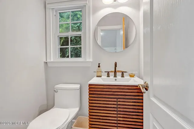 a bathroom with a sink a toilet and a mirror