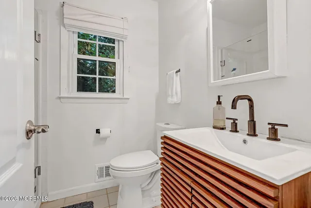 a bathroom with a sink a toilet and a mirror