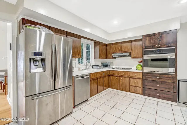 a kitchen with granite countertop a refrigerator stove and sink